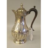 A late Victorian silver pear shape, demi-reeded and stop-fluted hot water pot with a hinged cap,