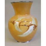 A 20thC peach coloured enamel vase of squat, bulbous form with a wide, flared neck, decorated with a