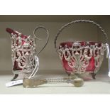 Early 20thC cranberry coloured glass and cast metal tableware, viz. a sugar bowl and a cream jug