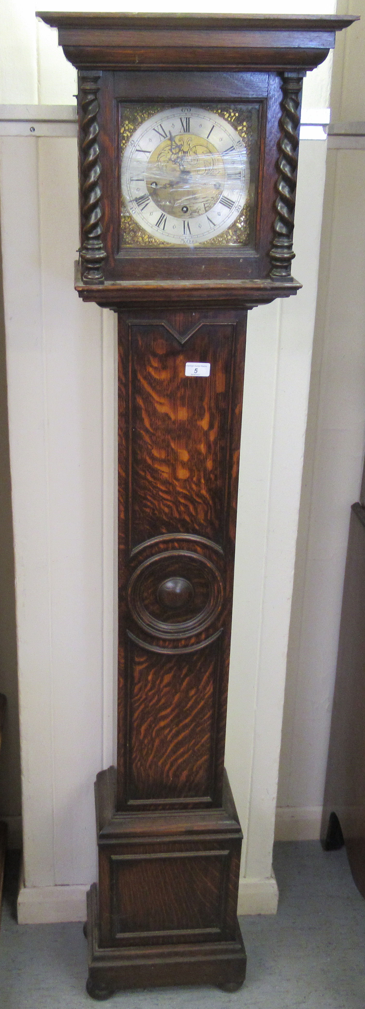 A 1920s oak cased Grandmother clock; the 8 day movement faced by a silvered Roman dial  69"h