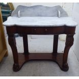 An early 20thC walnut washstand, the drop-in serpentine front marble top with a galleried back, over