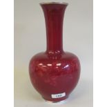 A 20thC ruby coloured enamel, bulbous bottle vase, having a long narrow neck and flared rim,