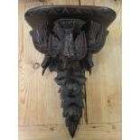 A late 19th/early 20thC stained and carved pine wall bracket, featuring three birds, fruit and