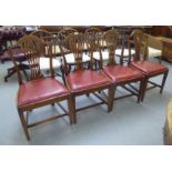 A set of four 1920s oak framed, pierced splat back dining chairs, the later red hide covered drop-in