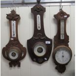 Three early 20thC oak framed barometers, each with an enamelled Arabic dial  19" - 21"h