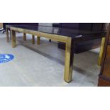 A modern lacquered brass framed coffee table, the drop-in glass top raised on square legs  15"h