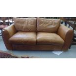 A modern two person settee upholstered in stitched brown hide with a straight back and level arms