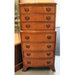 A modern walnut finished seven drawer tallboy, raised on bracket feet  43"h  20"w