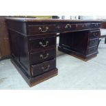 A late Victorian mahogany nine drawer, twin pedestal desk, on a plinth  29"h  60"w