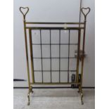 An early/mid 20thC lacquered brass framed firescreen, set with a lead glazed panel, raised on