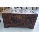 A post 1950s Chinese profusely carved camphorwood chest with straight sides and a hinged lid, raised