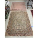 Two rugs, viz a Persian example profusely decorated with flora on a multi-coloured ground  47" x
