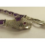 A silver coloured metal snake bracelet, set with amethysts