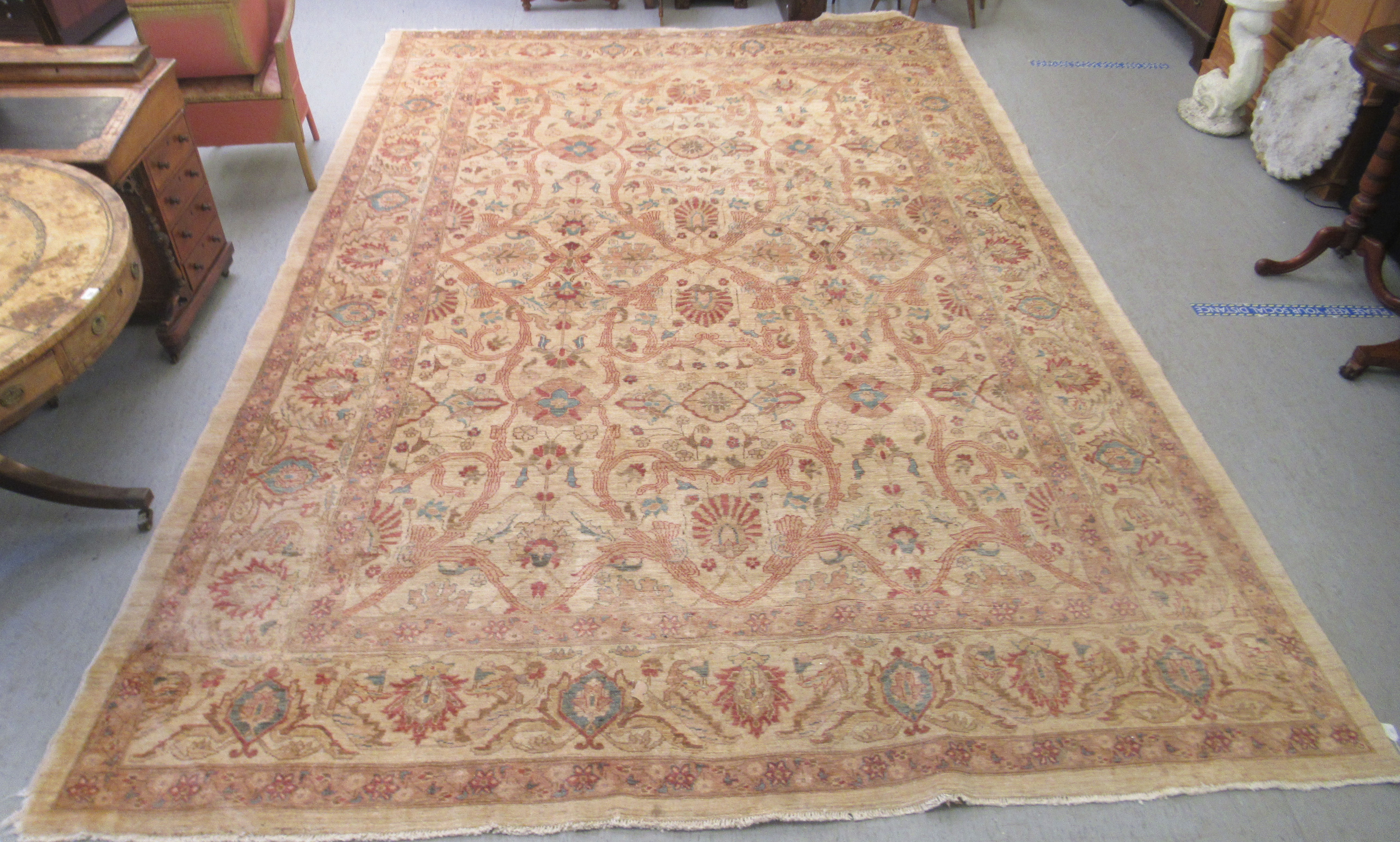 A Persian carpet, decorated with repeating stylised floral designs, on a cream coloured ground  116"