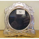 An Art Nouveau style, decoratively pressed silver coloured metal glazed photograph frame with a