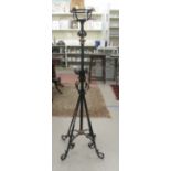 A mid 20thC brass and black painted wrought metal standard lamp  51"h