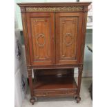 An early 20thC Empire Revival style mahogany cabinet with a pair of panelled doors, over a single
