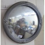 A 20thC mirror, the plate set in a cast metal frame  18"dia