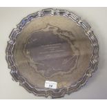 A Georgian style silver salver with a raised piecrust border, elevated on foliate scrolled feet