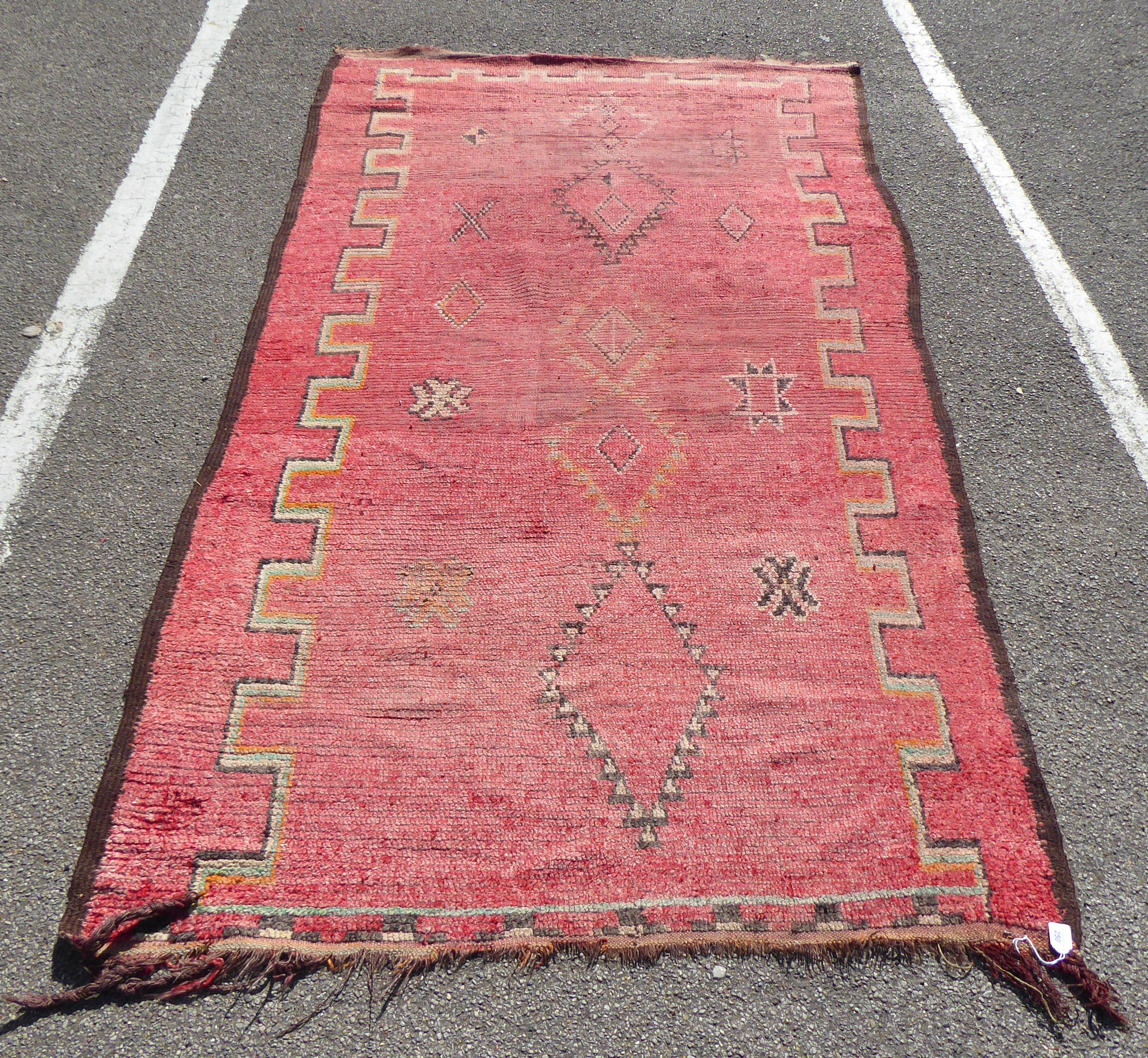 An early 20thC Turkish Kelleh rug with geometric motifs on a red ground  108" x 56"