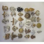Approx. thirty military regiment cap badges and other insignia, some copies: to include Warwickshire