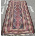 A Turkish Kelim rug, decorated with repeating geometric and other designs, on a brown ground  54"