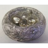 A late Victorian loaded silver novelty paperweight, fashioned as a hedgerow bird's nest with four