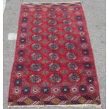 A Bokhara rug, decorated with three columns of eight octagonal guls, bordered by stylised designs,