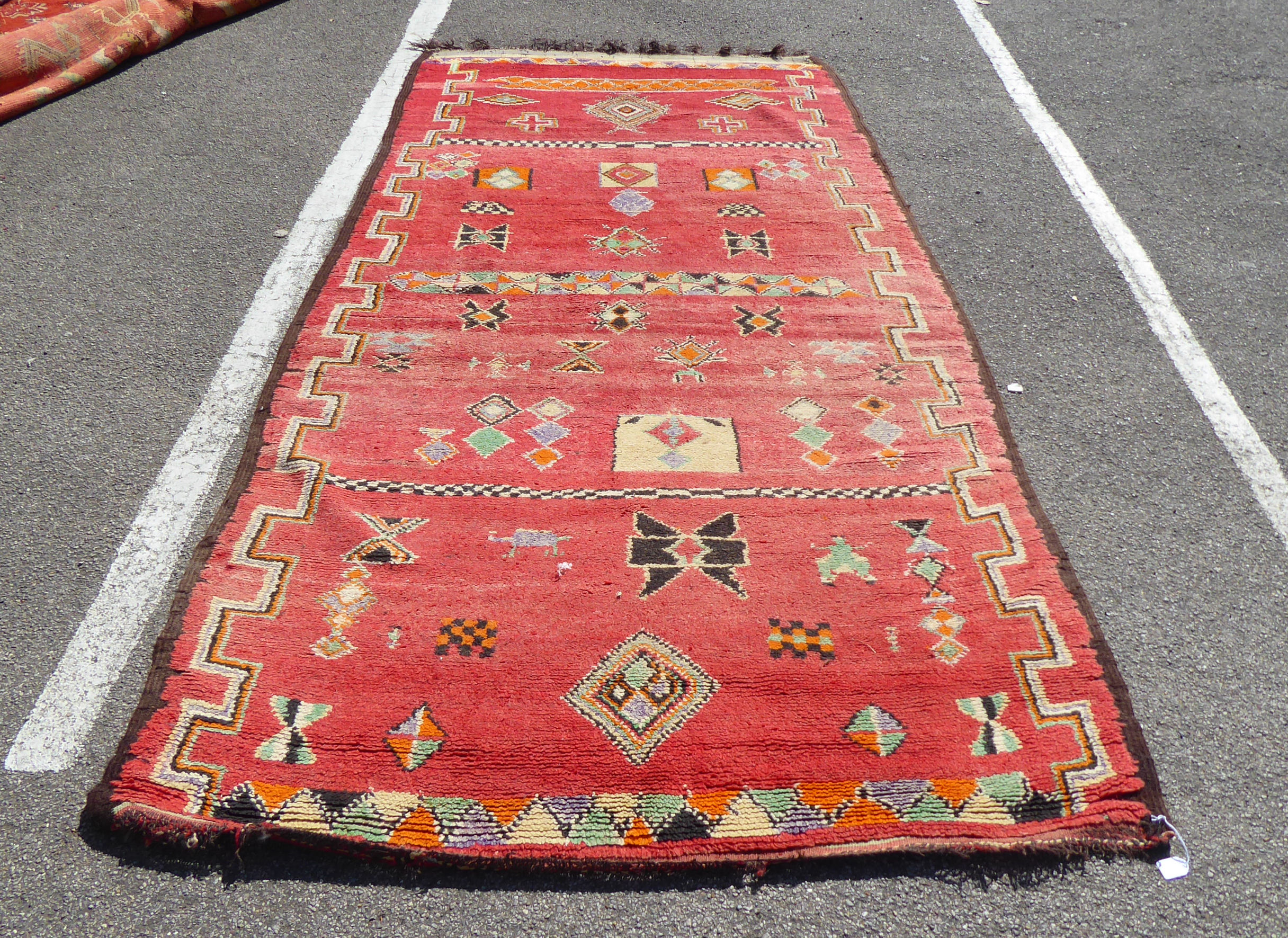 An early 20thC Turkish Kelleh with geometric and zoomorphic motifs on a red ground with Kelim