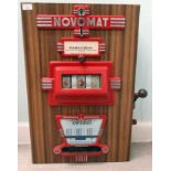 A vintage Novemat 'one arm bandit' table-top/hanging fruit machine, in a wood effect Fablon type