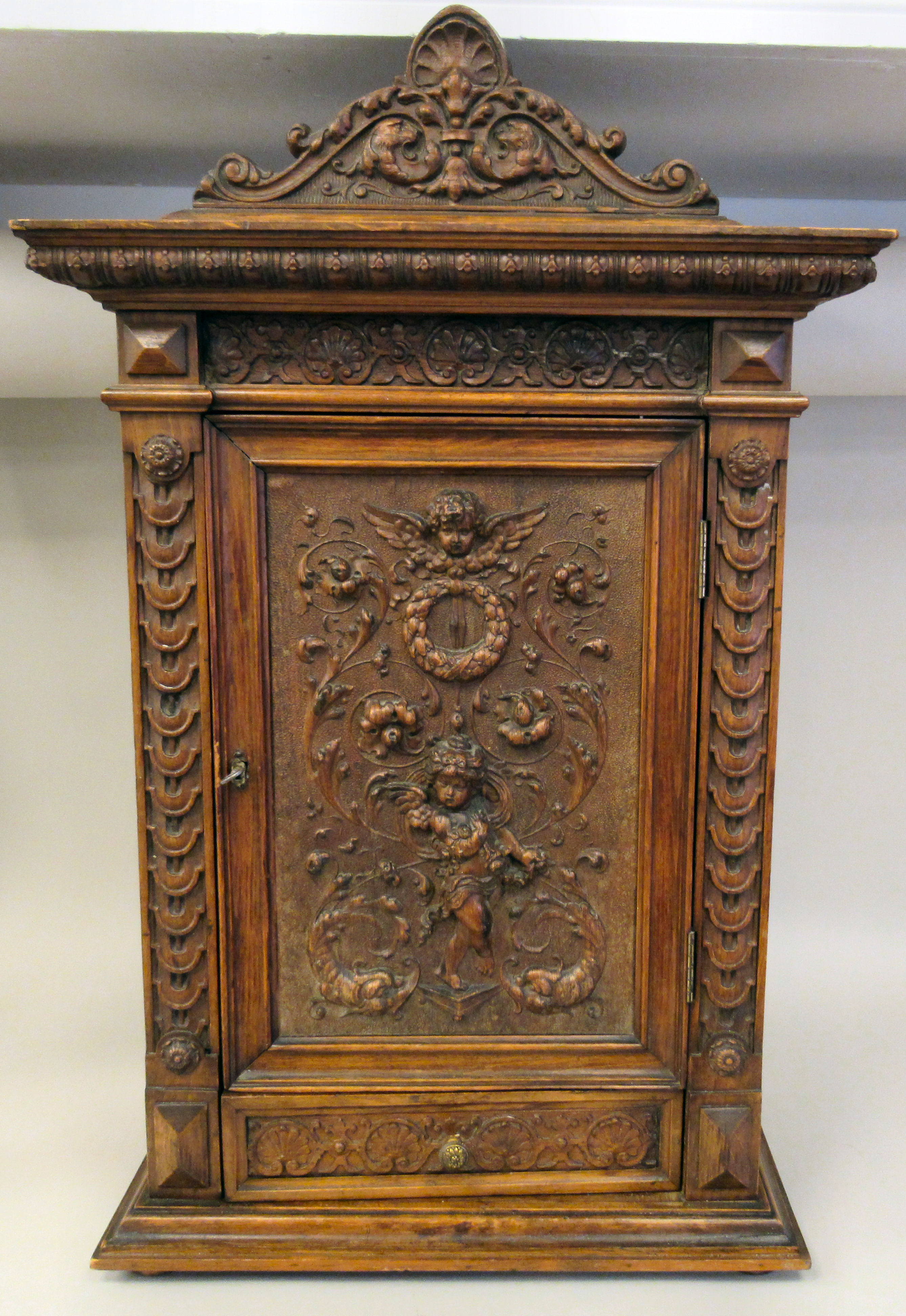 A late 19thC Continental finely carved, hanging cupboard with an upstand pediment and lockable