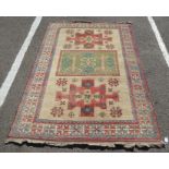 A Kazak style Caucasian rug with geometric motifs on a cream coloured ground  86" x 60"