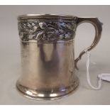An Edwardian silver Christening mug of tapered form with a cast and chased oakleaf and acorn