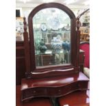 A modern mahogany dressing table mirror, the arched bevelled plate over a serpentine front, three