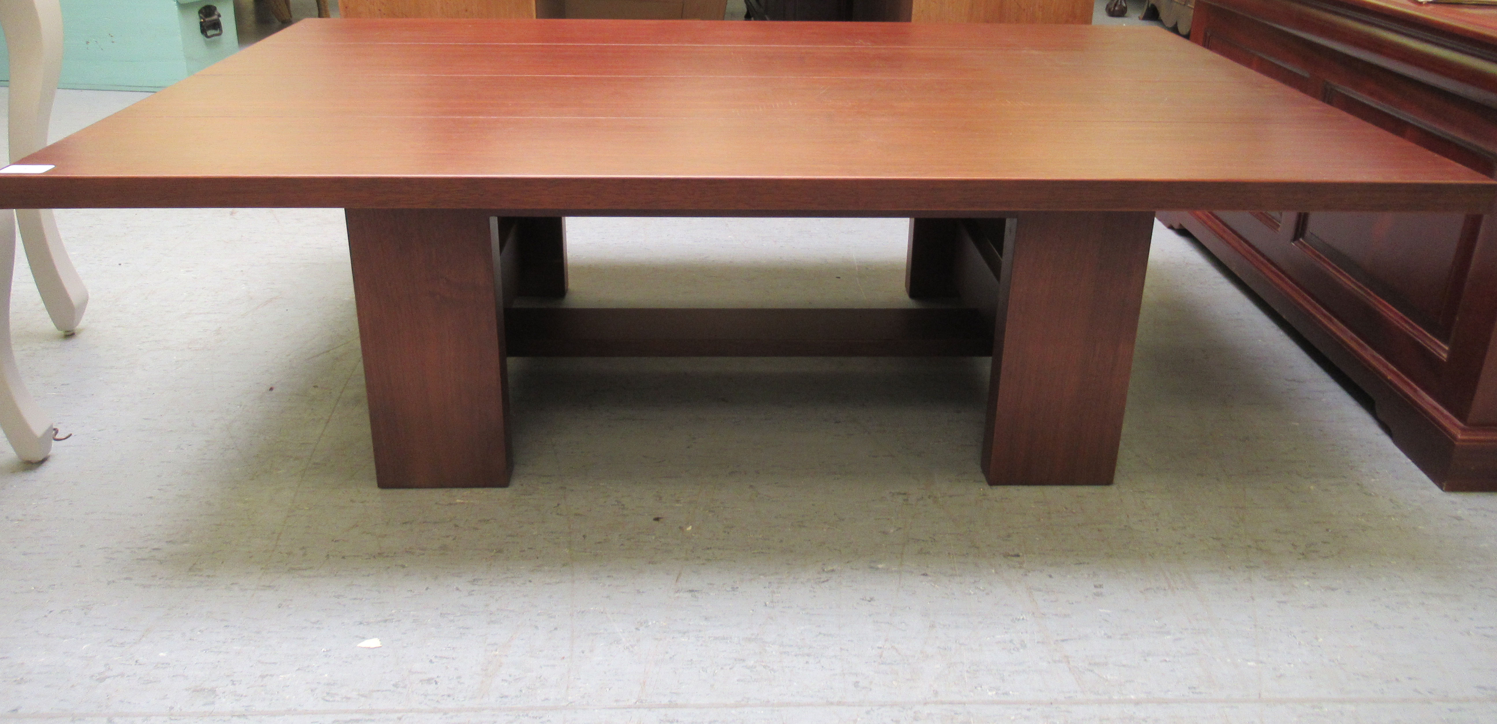 A modern teak coffee table, raised on block legs  16"h  51"w  31"deep