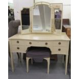 An Edwardian cream painted serpentine front dressing table with five short drawers, surmounted by