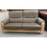 A modern bleached oak showwood framed, two person settee, upholstered in stitched light brown