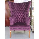 A modern part button and stud upholstered vibrant pink fabric, enclosed high wingback enclosed