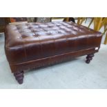 A modern rectangular footstool, part button and stud upholstered in antique finished mid brown hide,