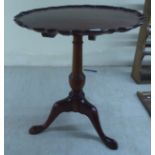 A reproduction of a Georgian mahogany pedestal table, the piecrust top over a turned column and