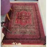 A Persian part silk woven prayer rug, decorated with repeating stylised designs, on a red ground