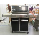 A Weber Genesis gas operated steel framed BBQ station, on casters  48"h  56"w