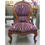A modern Victorian style mahogany framed salon chair, upholstered in stylised mauve patterned
