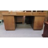 An Art Deco mahogany fully secured twin pedestal, three drawer desk with a satinwood lined interior,