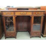 An Edwardian mahogany desk with a low platform, two drawer top over three frieze drawers and a
