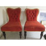 A pair of late 19thC rosewood and mahogany showwood framed nursing chairs, the later part button red