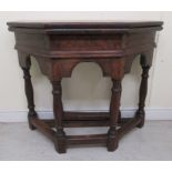 An early 17thC style oak credence table, the foldover top on an arcaded apron, raised on baluster