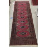 A Persian runner with diamond motifs, on a pink and blue ground  33" x 102"