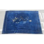 An Oriental themed washed woollen carpet, decorated with a dragon, on a blue ground  98" x 130"