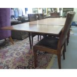 A 1970s G-Plan teak draw leaf dining table, raised on a stylised underframe and turned, tapered legs